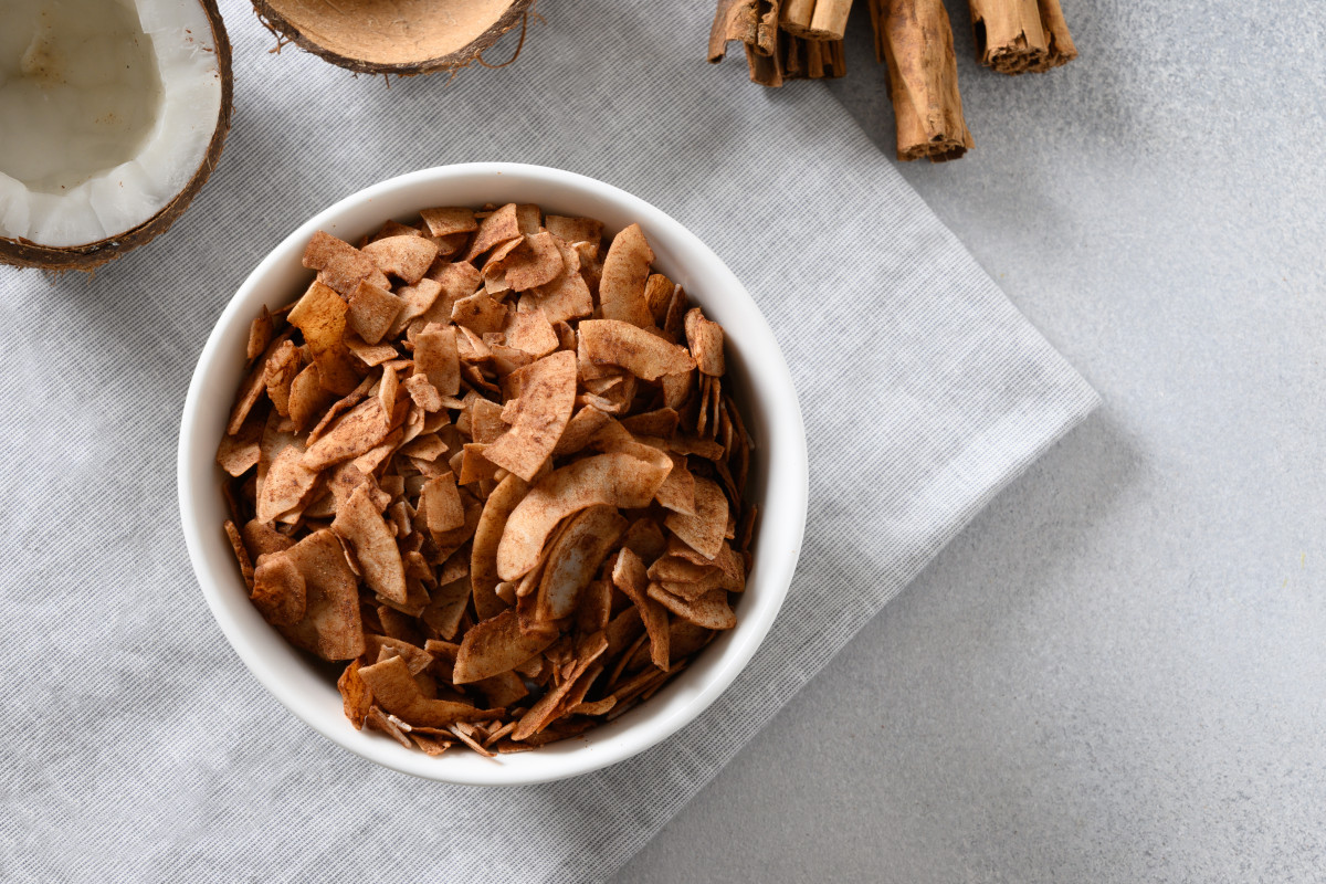 croustilles de noix de coco avec cannelle en poudre dans un bol dessert vegetalien sans sucre